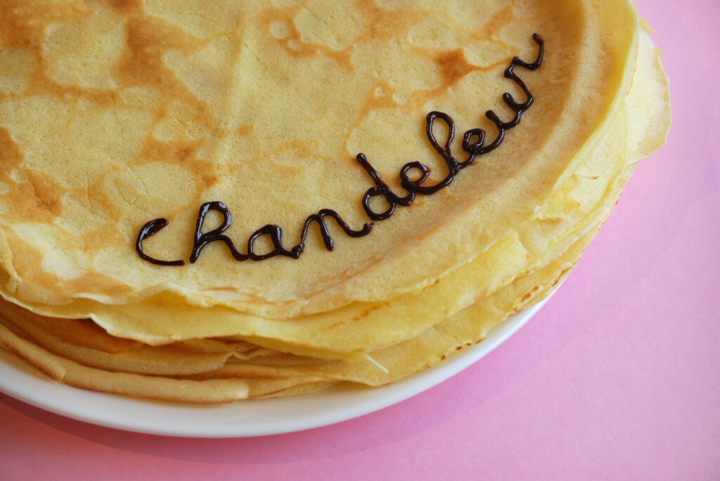 assiettes de crêpes le mot chandeleur est écrit dessus en chocolat